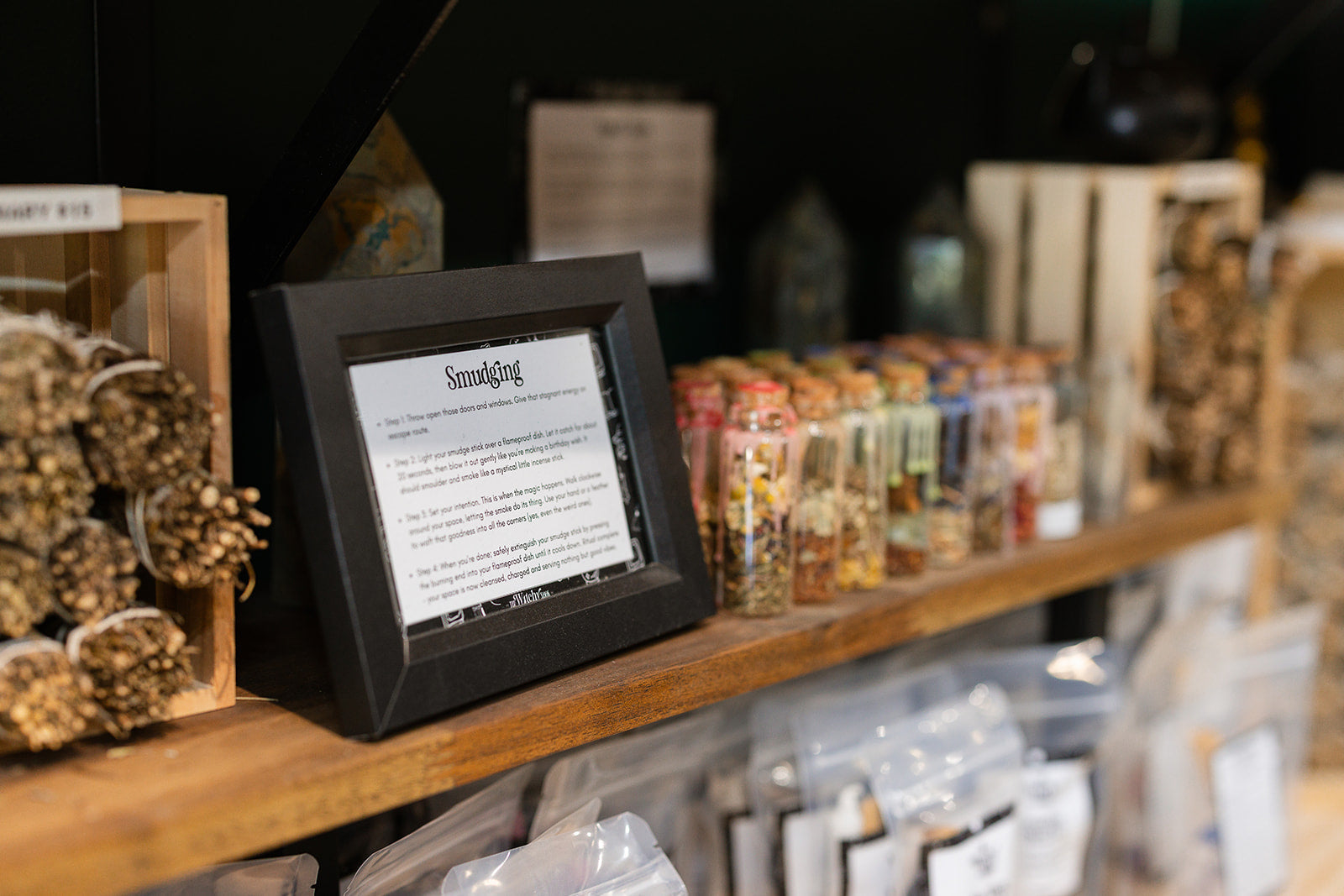 A shelf in The Witchy Nook filled with smudging sticks and spell jars