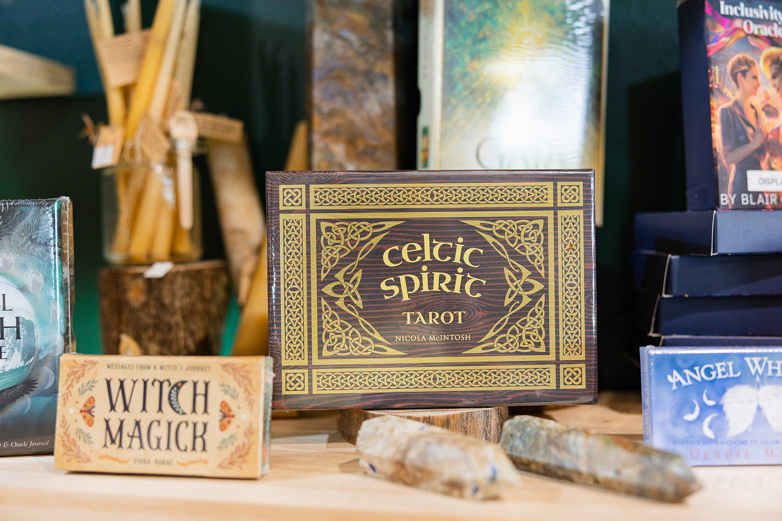 A shelf holding crystals and tarot card boxes