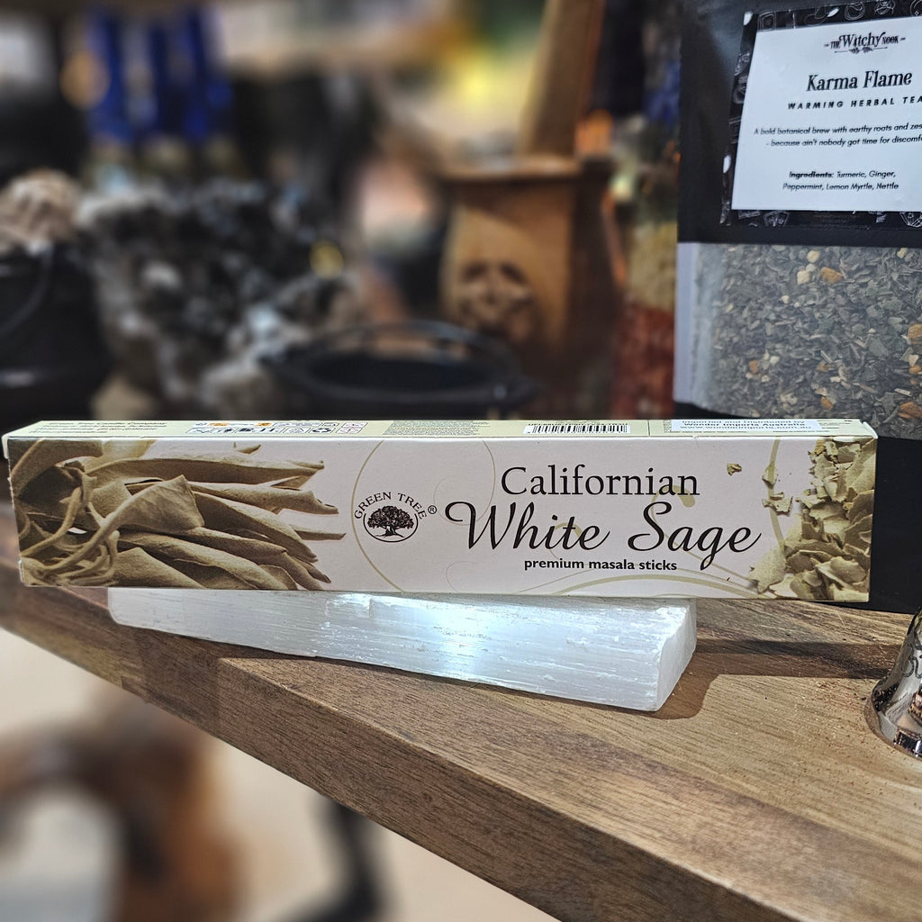 ‘White Sage Incense’ Displayed on a wooden table surrounded by crystals and herbs. 