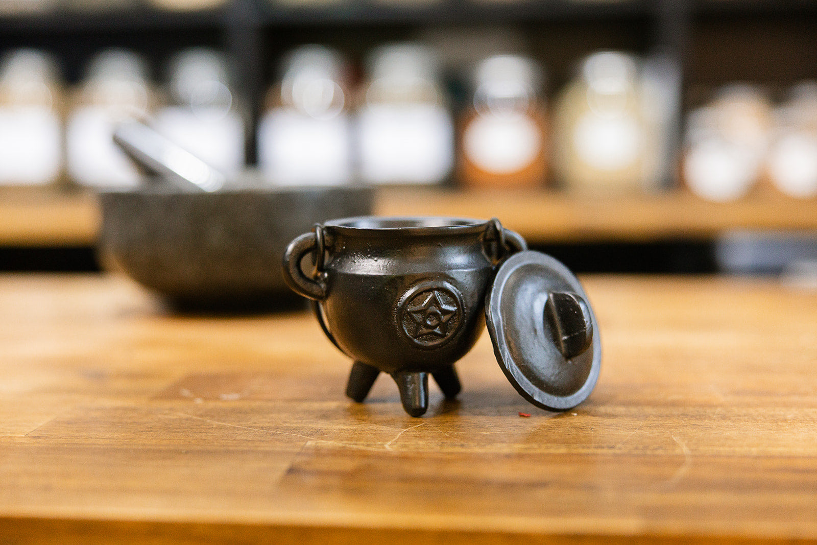 Cauldron - Cast Iron Pentagram design displayed on a wooden bench with a blurred background.