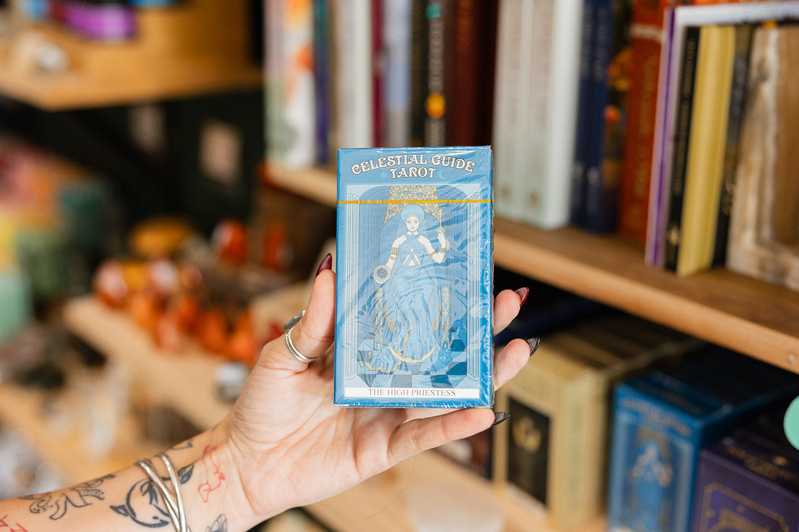 Celestial Guide Tarot Deck (With Book) displayed in front of collection of tarot cards and books