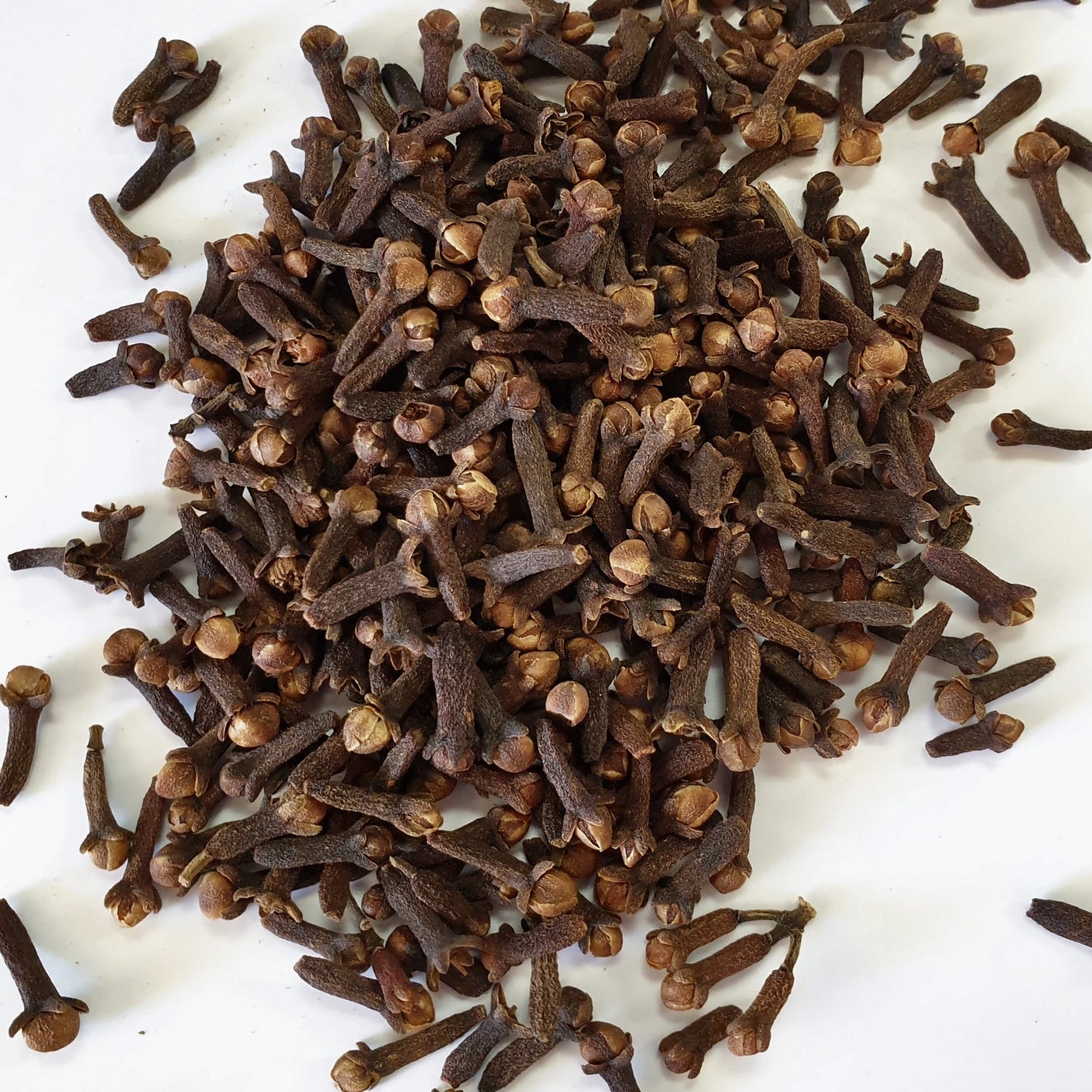 Cloves herb on a white surface.