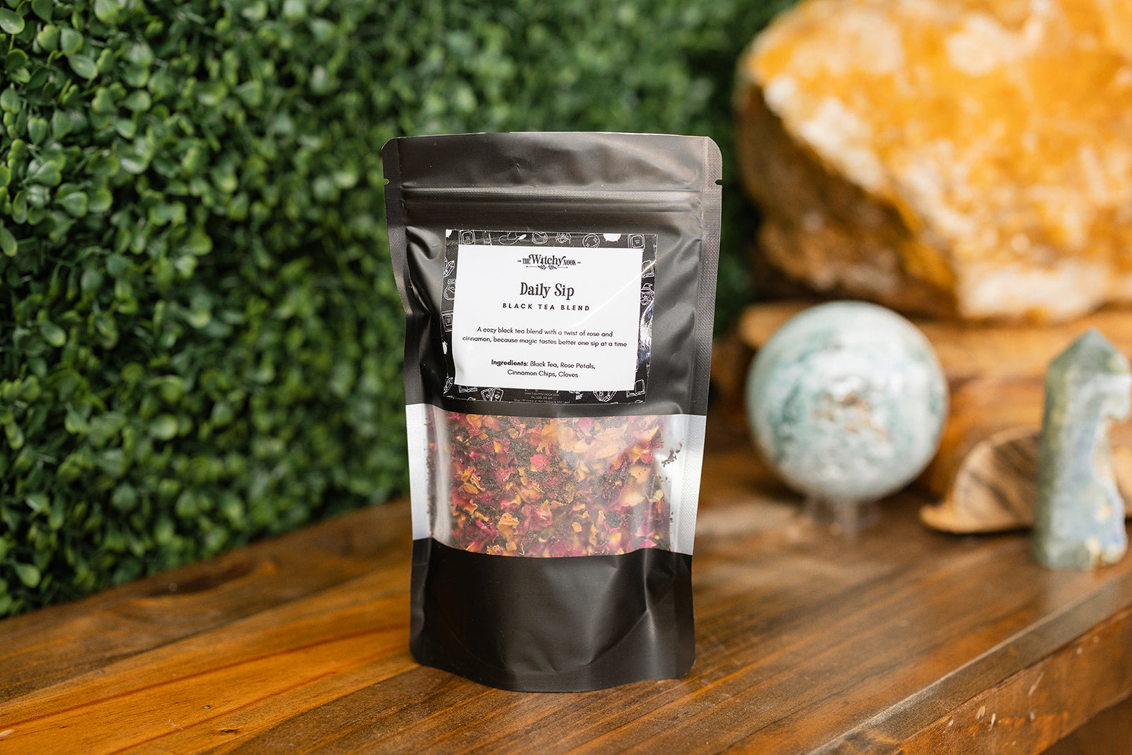 Daily Sip Tea Blend displayed on a timber bench with crystals in the background