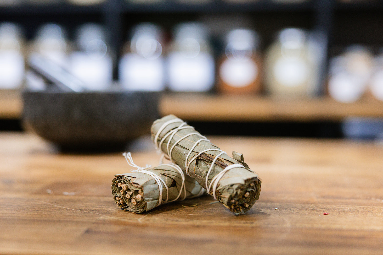 Eucalyptus Smudge Stick on timber bench with mortar and pestle in background