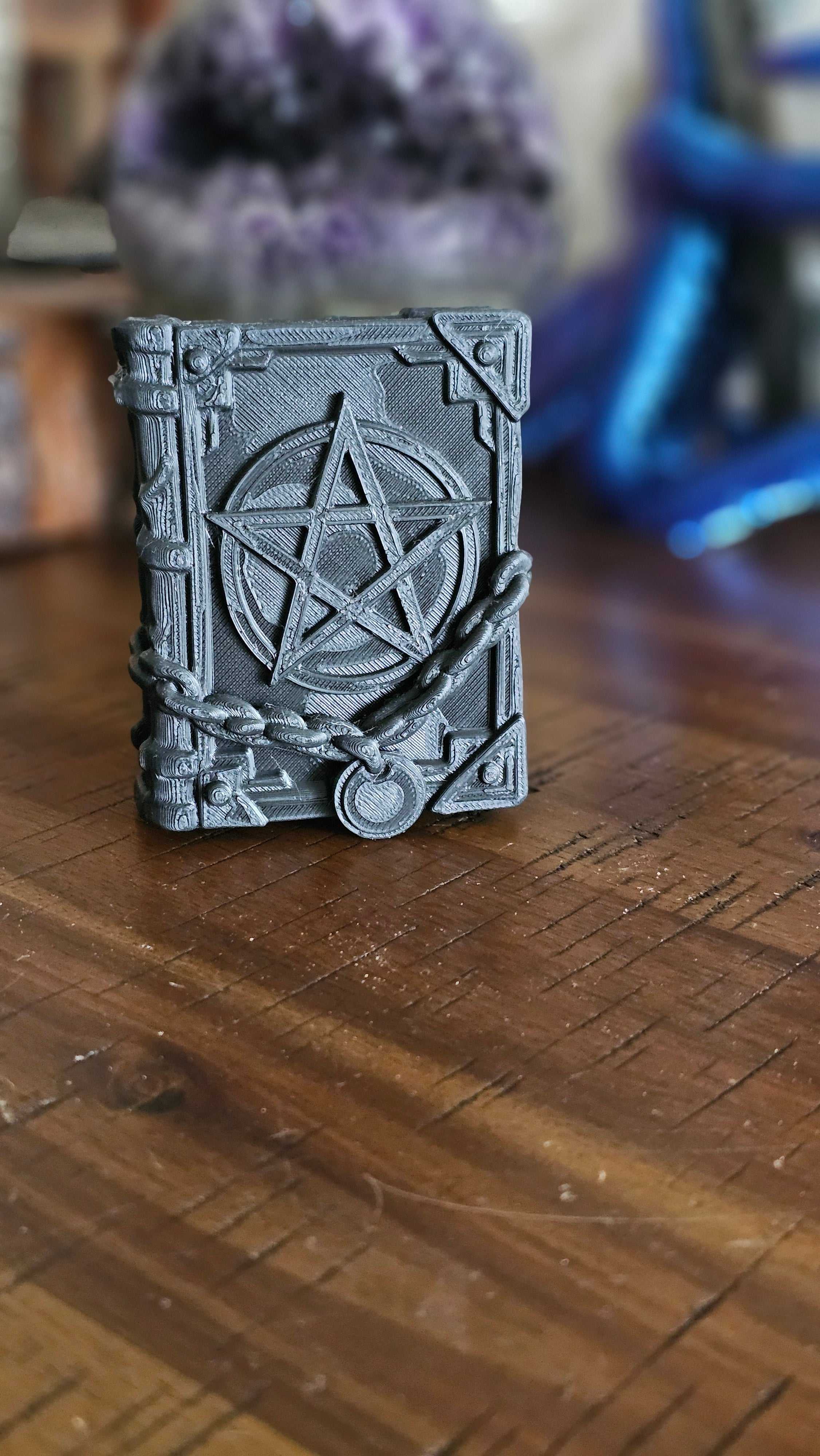Forbidden spell book 3d PLA displayed on a wooden surface with crystals in the background. 
