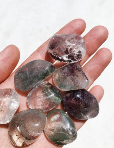 Crystals Garden Quartz Tumble in a persons hand on a white background