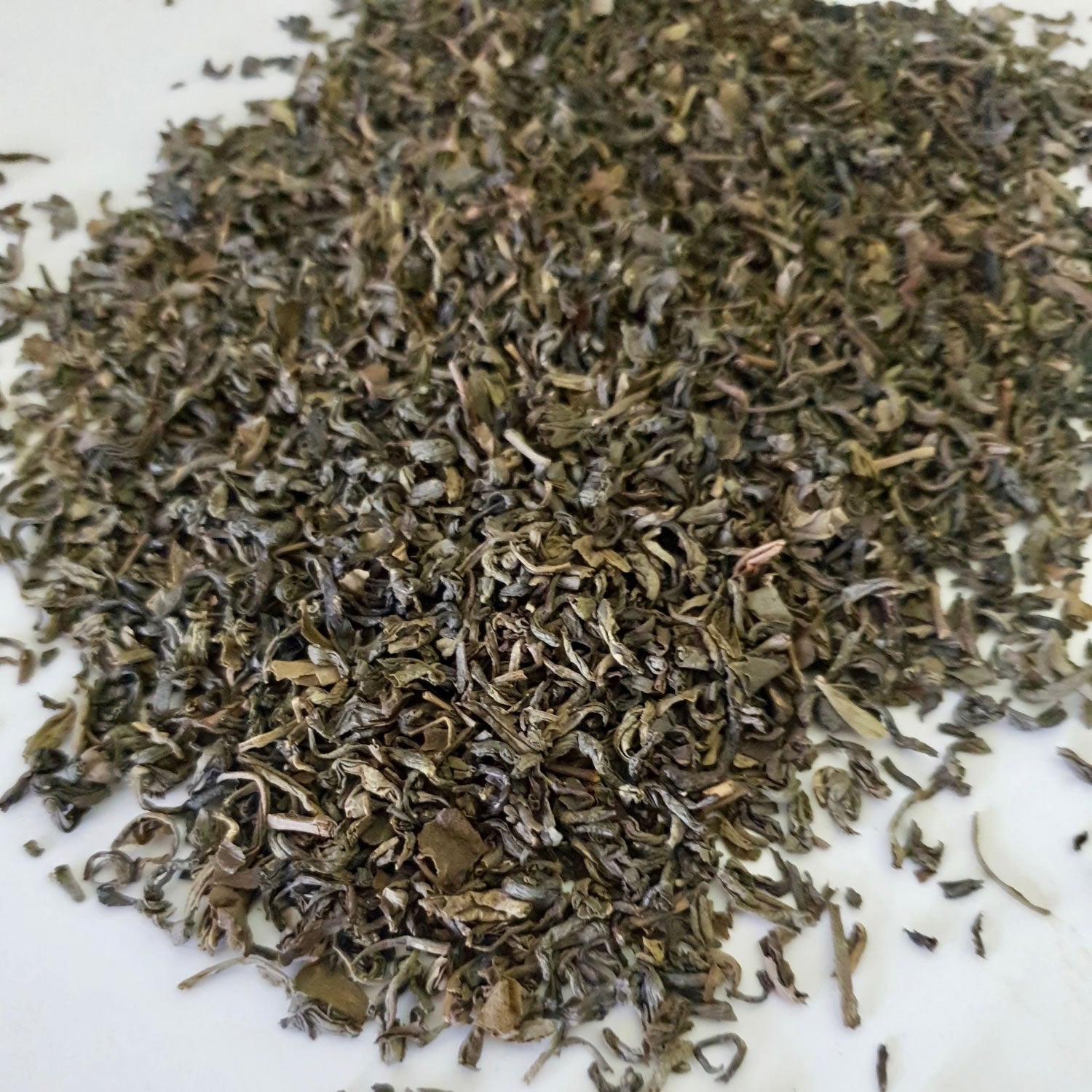 Green Tea Leaves herb on a white surface.