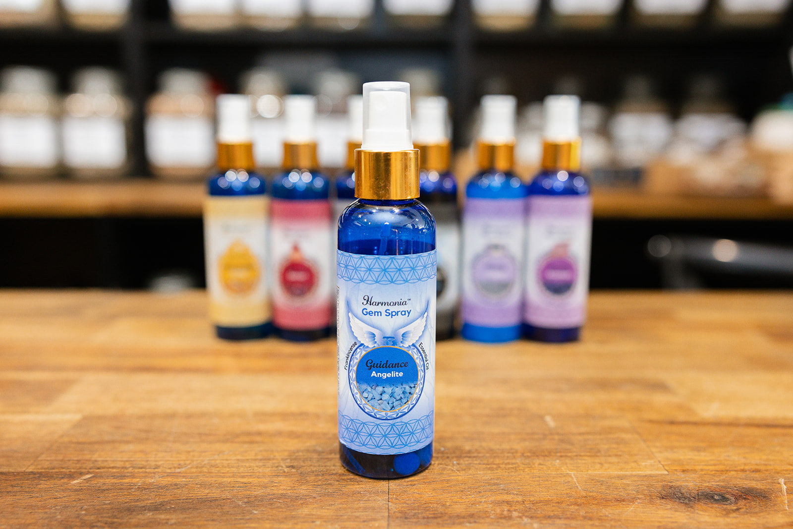 Bottle of Guidance Room Spray displayed in front of a collection on a wooden background