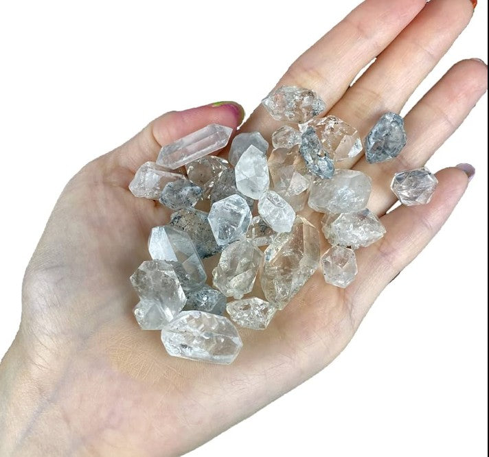 Crystals Herkimer Diamond in a persons hand with a white background