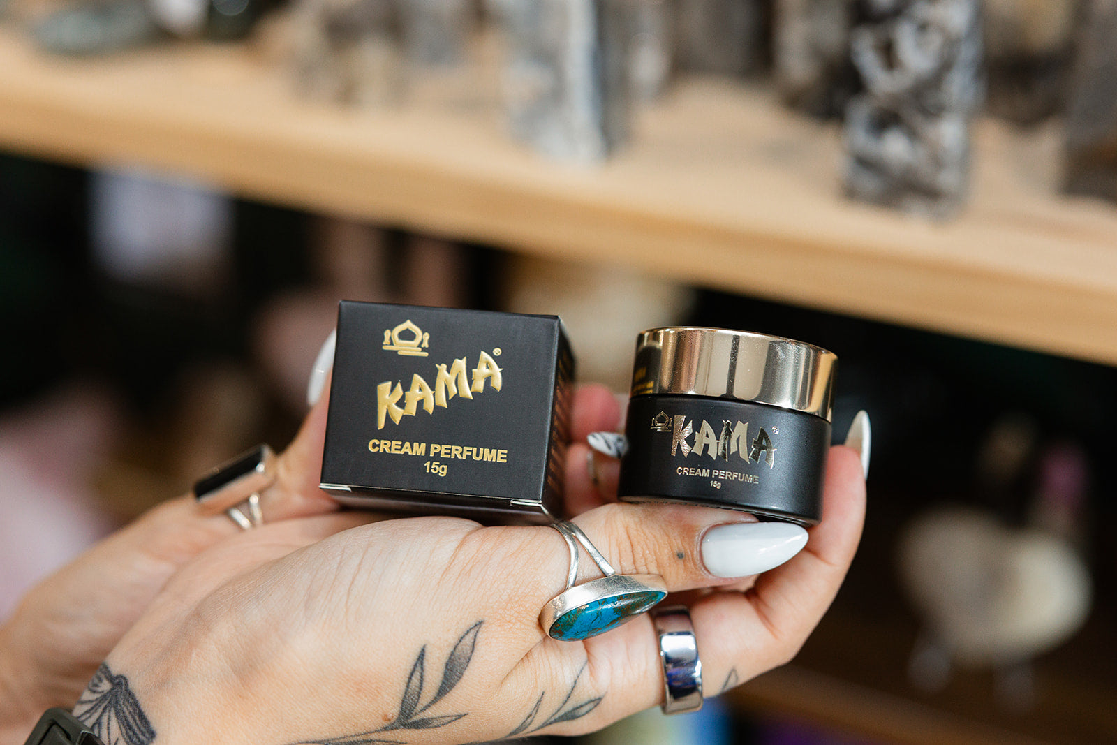 Kama Cream 15g product in a persons hand with a blurred background