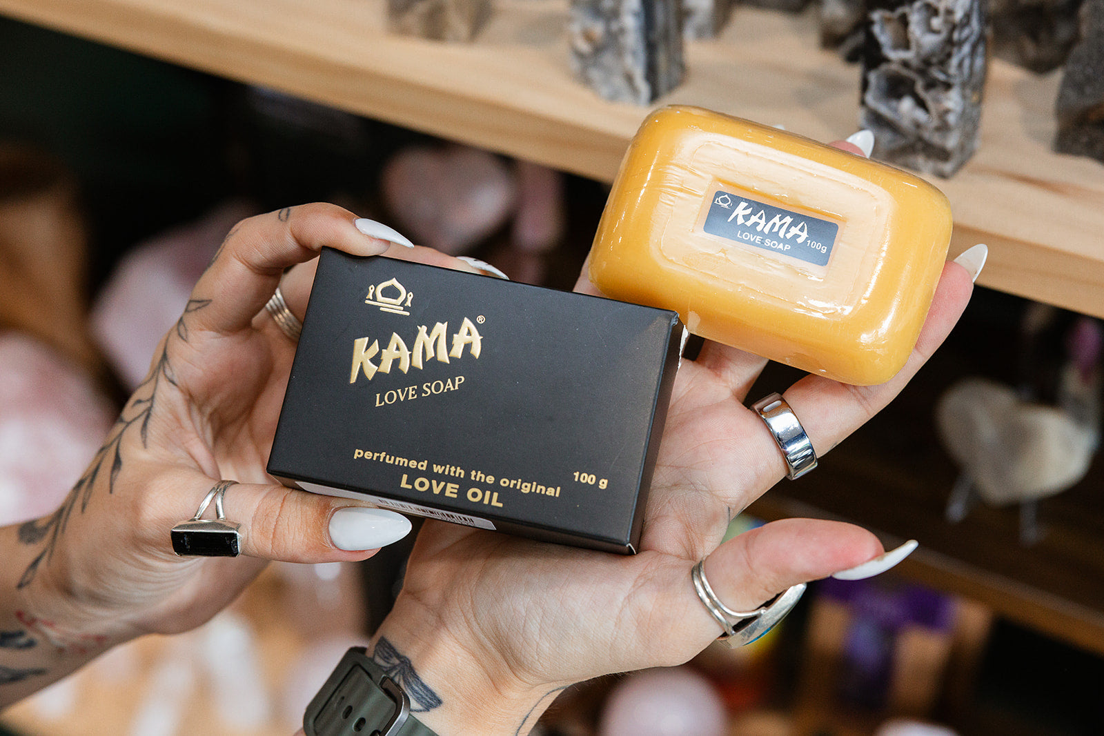 Kama Love Soap Bar product in a persons hand with a blurred background
