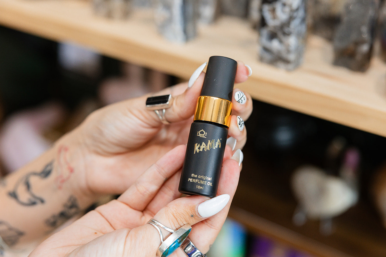 Kama Spray Perfume 15ml product shown in a persons hand with a blurred background