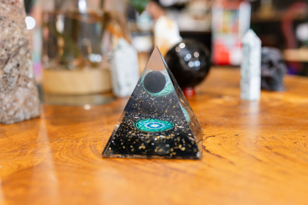 Pyramid-shaped object with a central design on a wooden surface