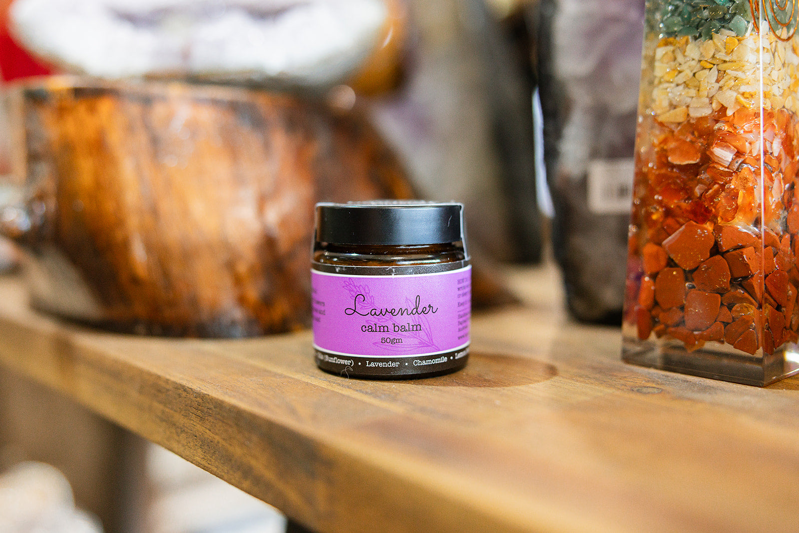 Lavender Calming Balm Displayed on a wooden bench with a blurred background