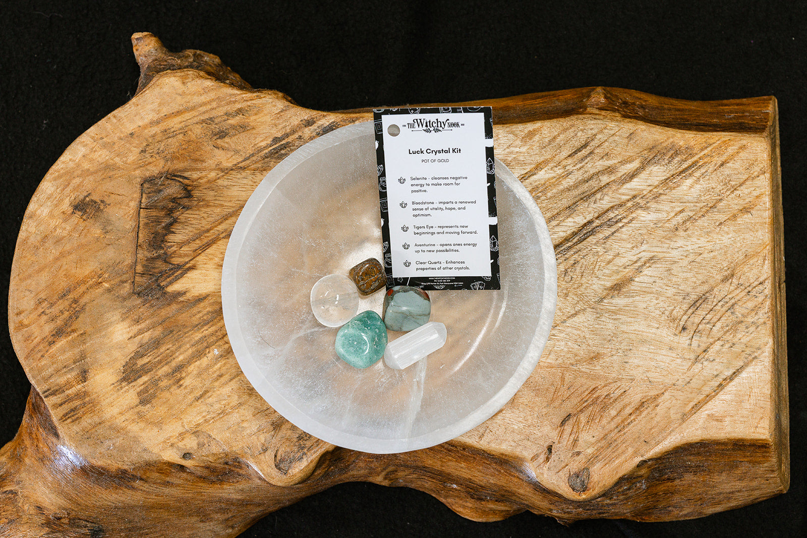 Packaged product labeled 'Luck Tumble Kit' by 'Witchy Nook' on a wooden surface in the background with products displayed in a bowl.