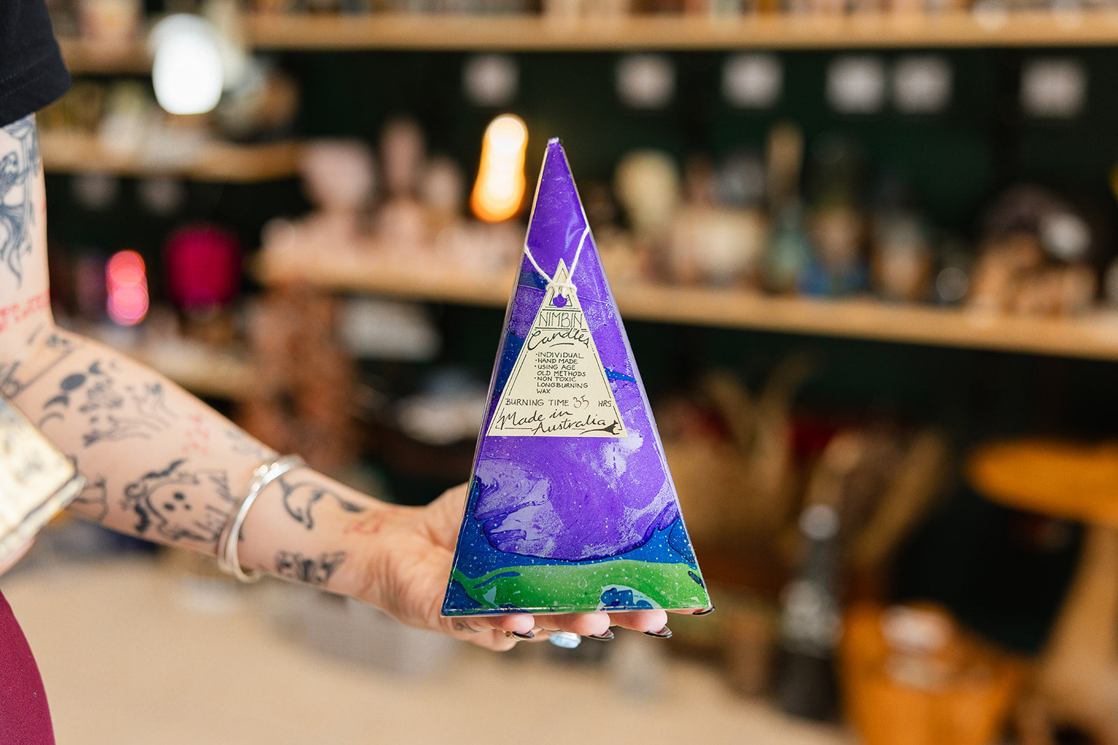 Marbled Pyramid 35hr - Nimbin Candles in a persons hand on a blurred background 
