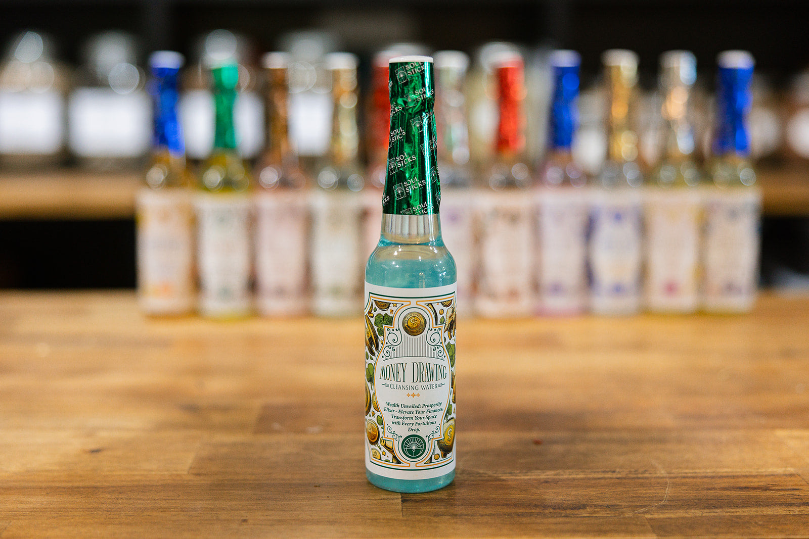 Money drawing Cleansing Water on a timber background with a collection of cleansing waters displayed in the background