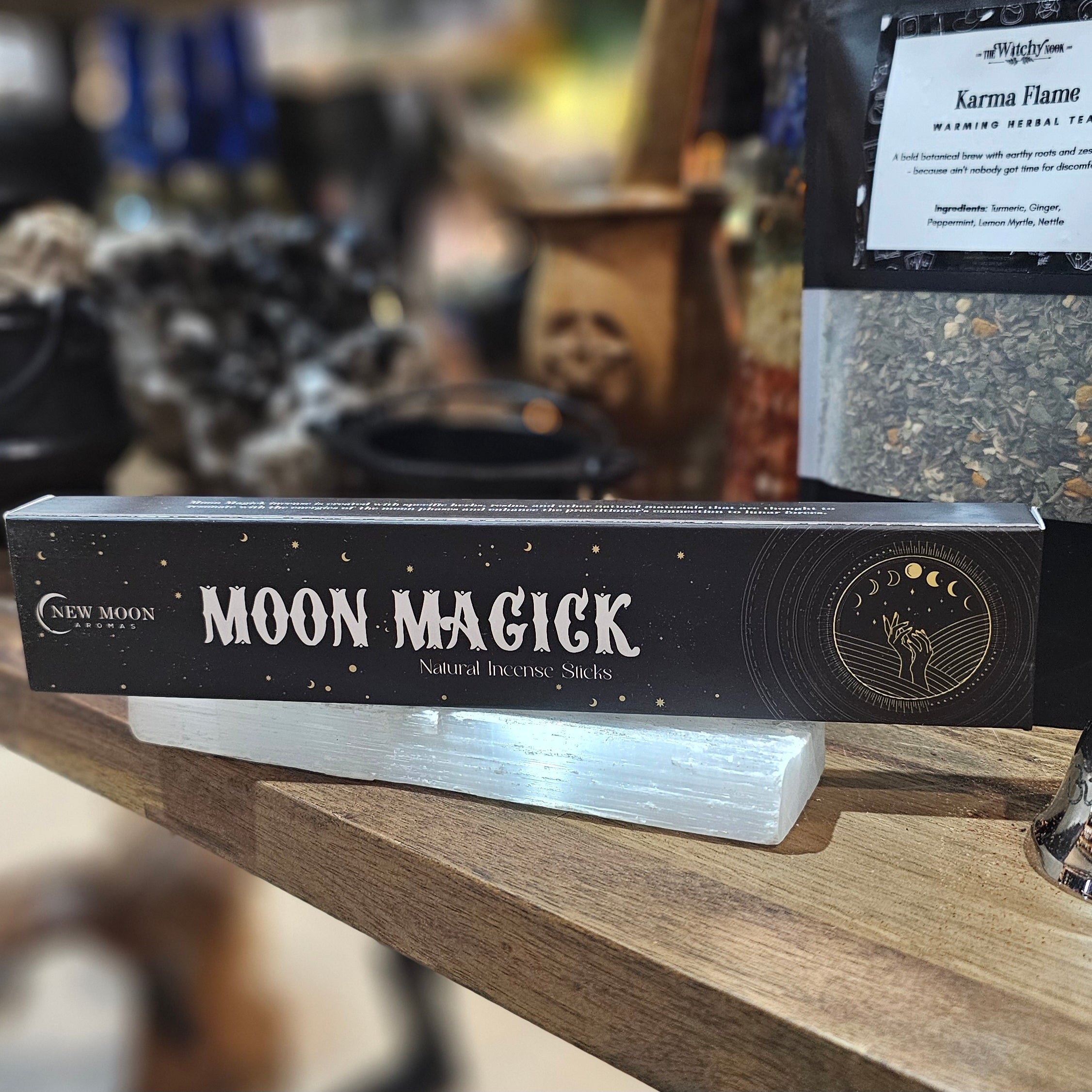 ‘Moon Magic Incense’ Displayed on a wooden table surrounded by crystals and herbs. 