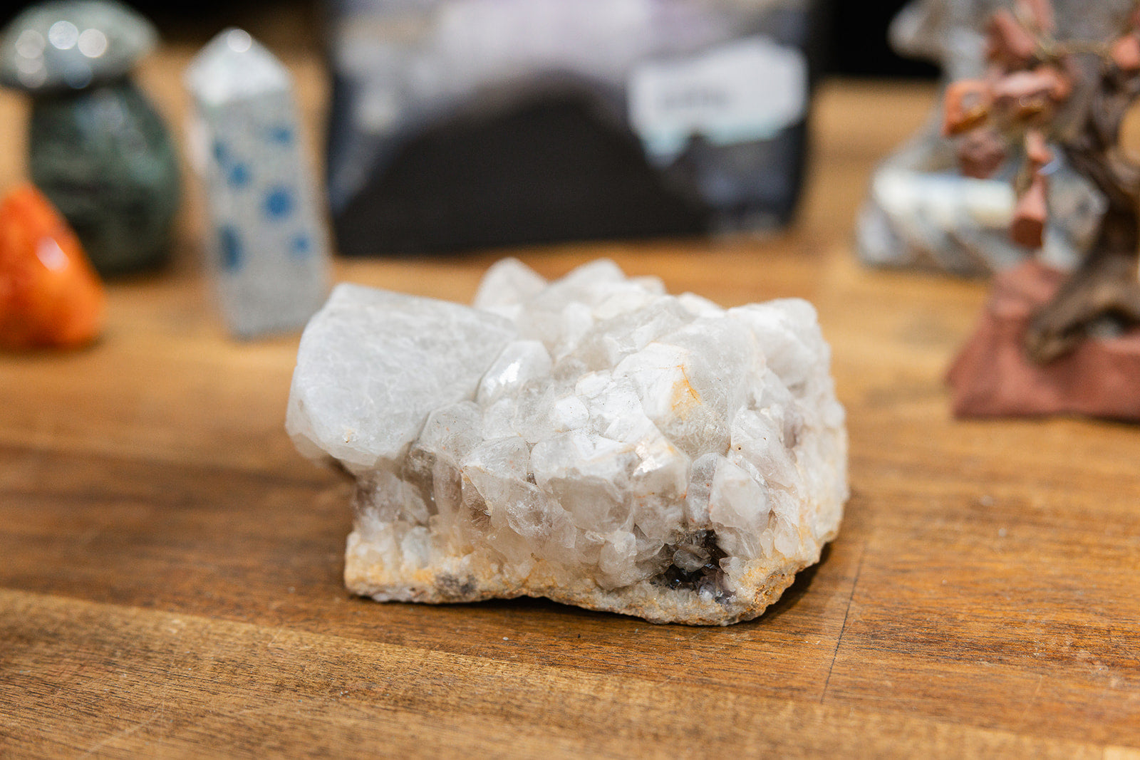 Natural crystal raw quartz cluster on wooden background