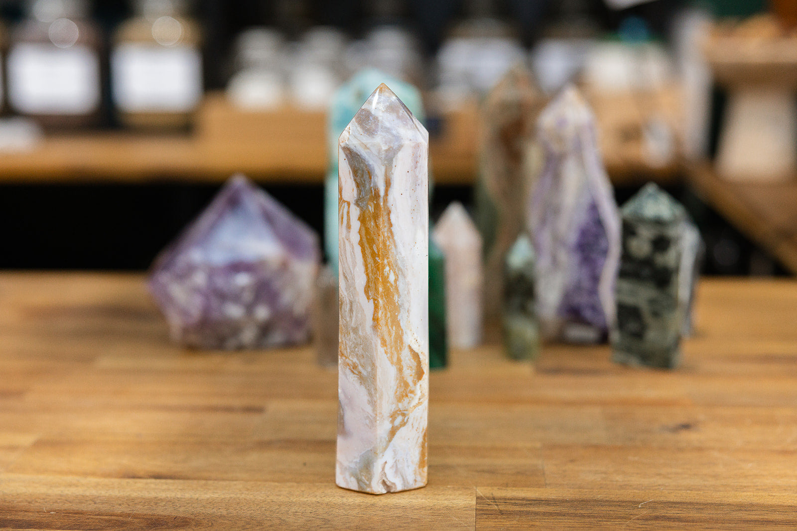 Natural crystal Ocean Jasper Tower with a collection of colourful towers on wooden background
