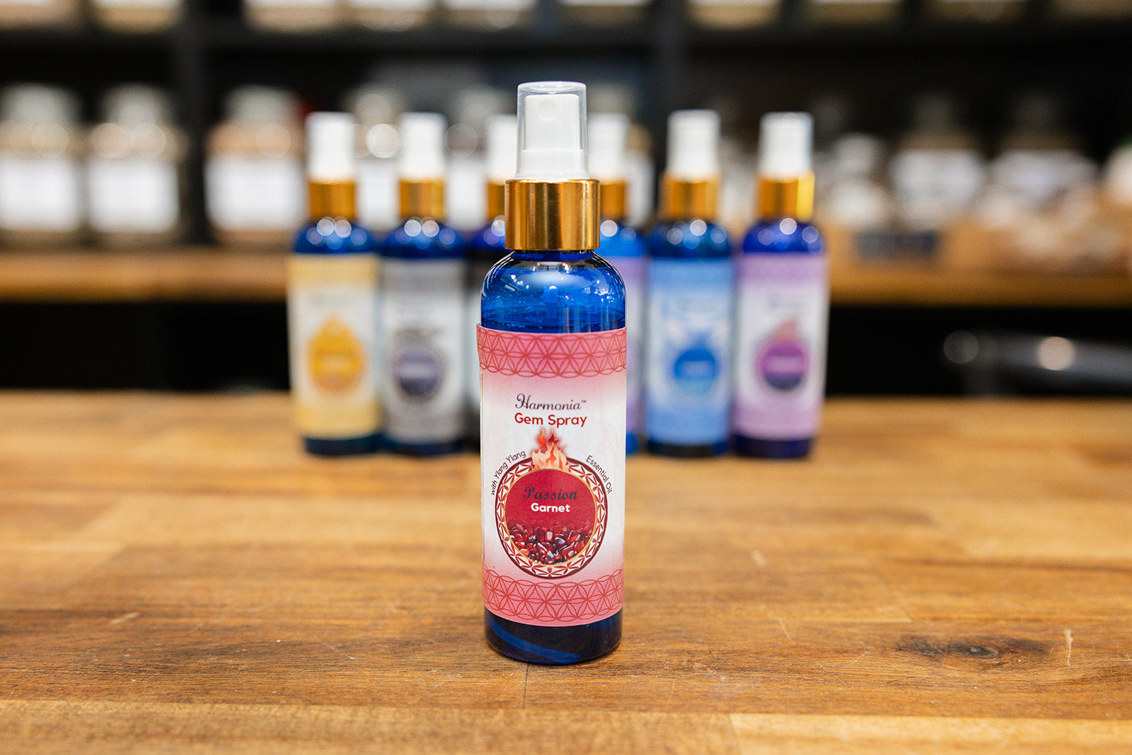Bottle of passion room spray displayed with collection of room sprays on wooden background