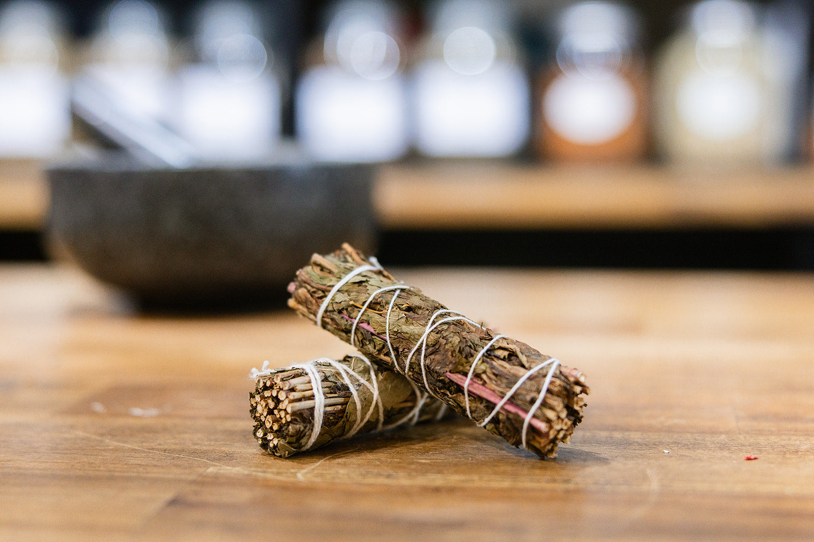 Peppermint smudge sticks on timber bench with mortar and pestle in background