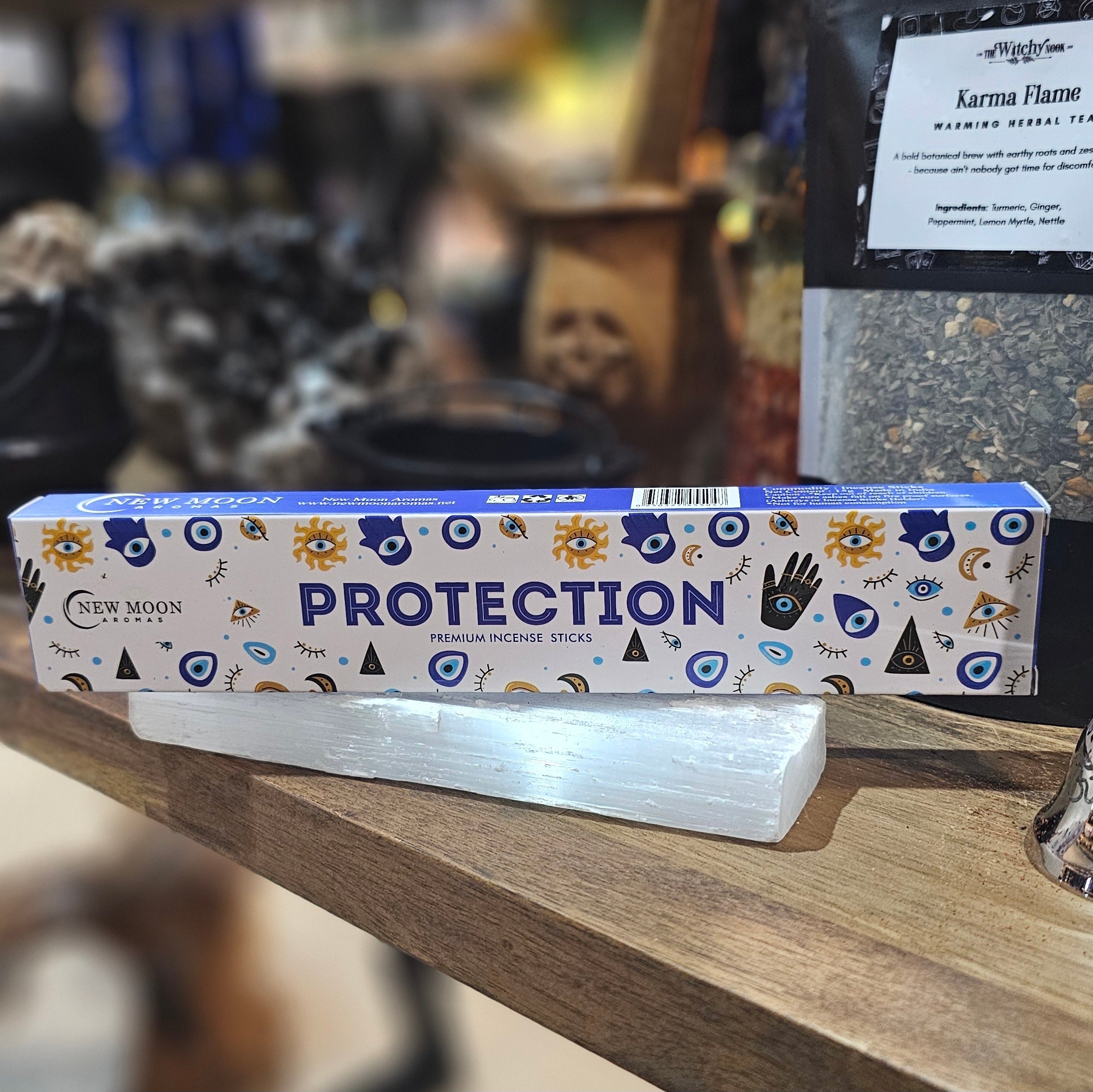 ‘Protection Incense’ Displayed on a wooden table surrounded by crystals and herbs. 
