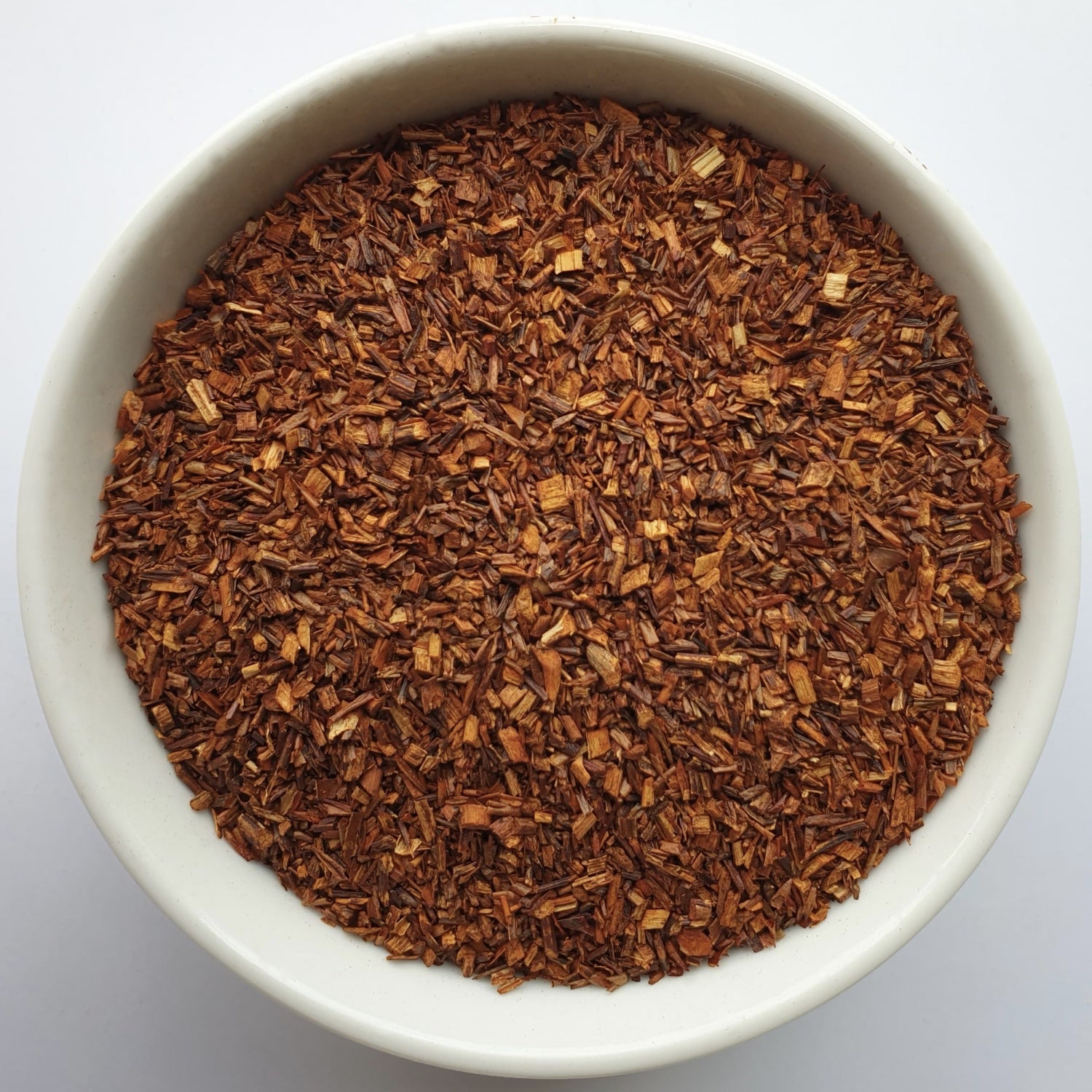 Rooibos Tea leaves herb on a white surface.