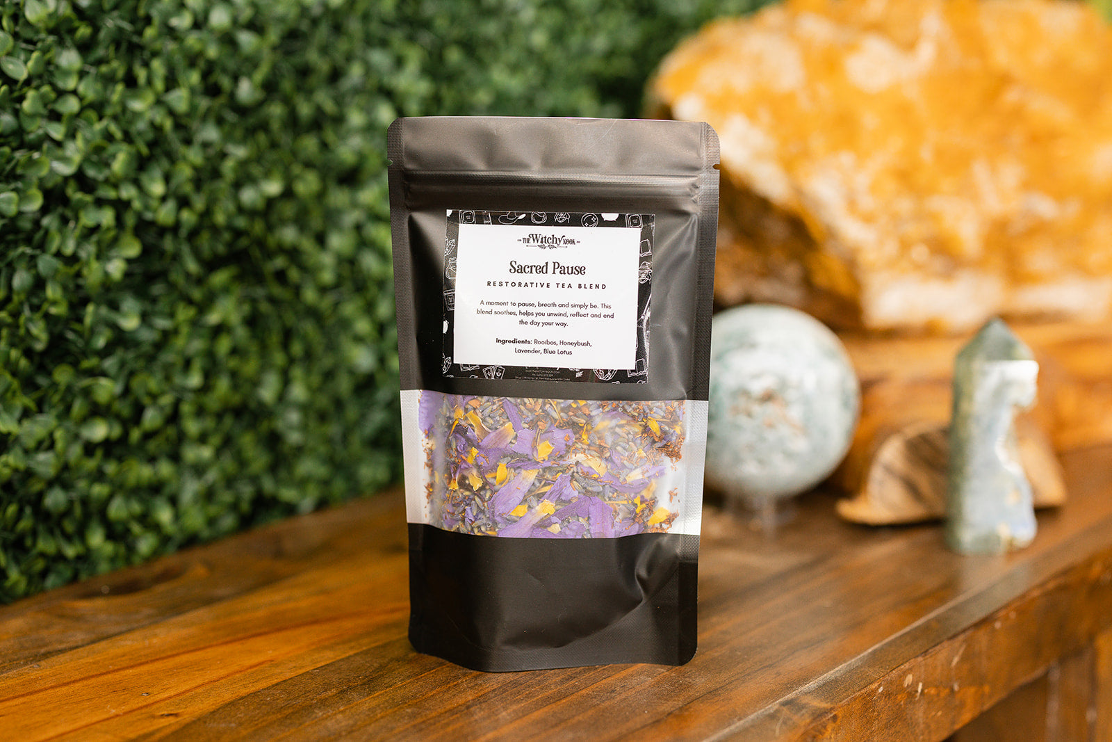 Sacred Pause Tea Blend on a timber bench with crystals in the background