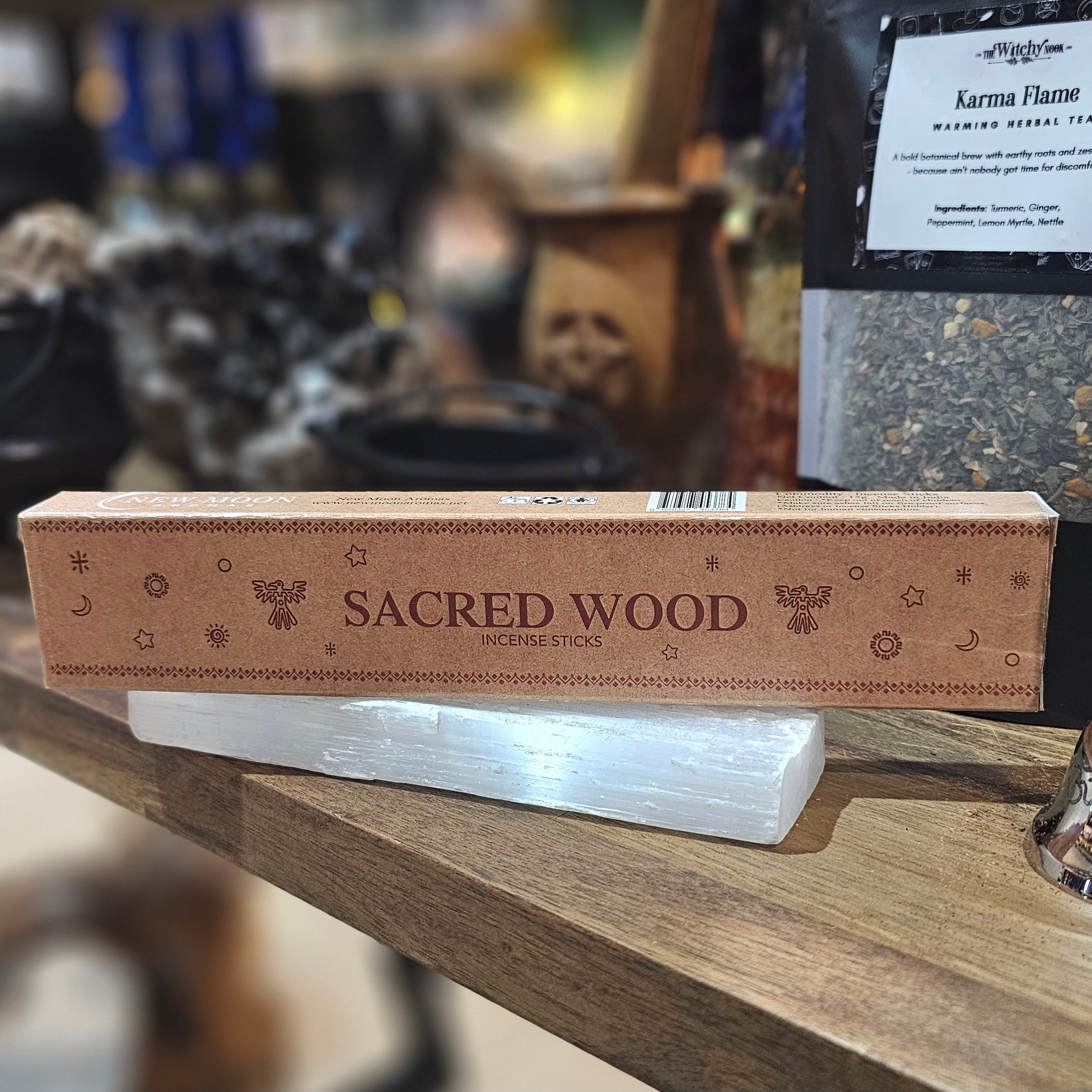 ‘Sacred Wood Incense’ Displayed on a wooden table surrounded by crystals and herbs. 