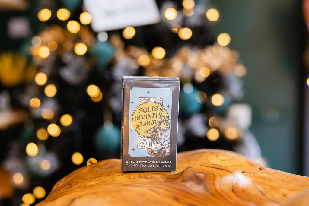 Solis Divinity - Black Holographic Tarot cards displayed on a wooden surface