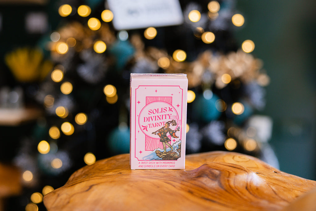 Solis Divinity - Pink Tarot deck displayed on a wooden surface