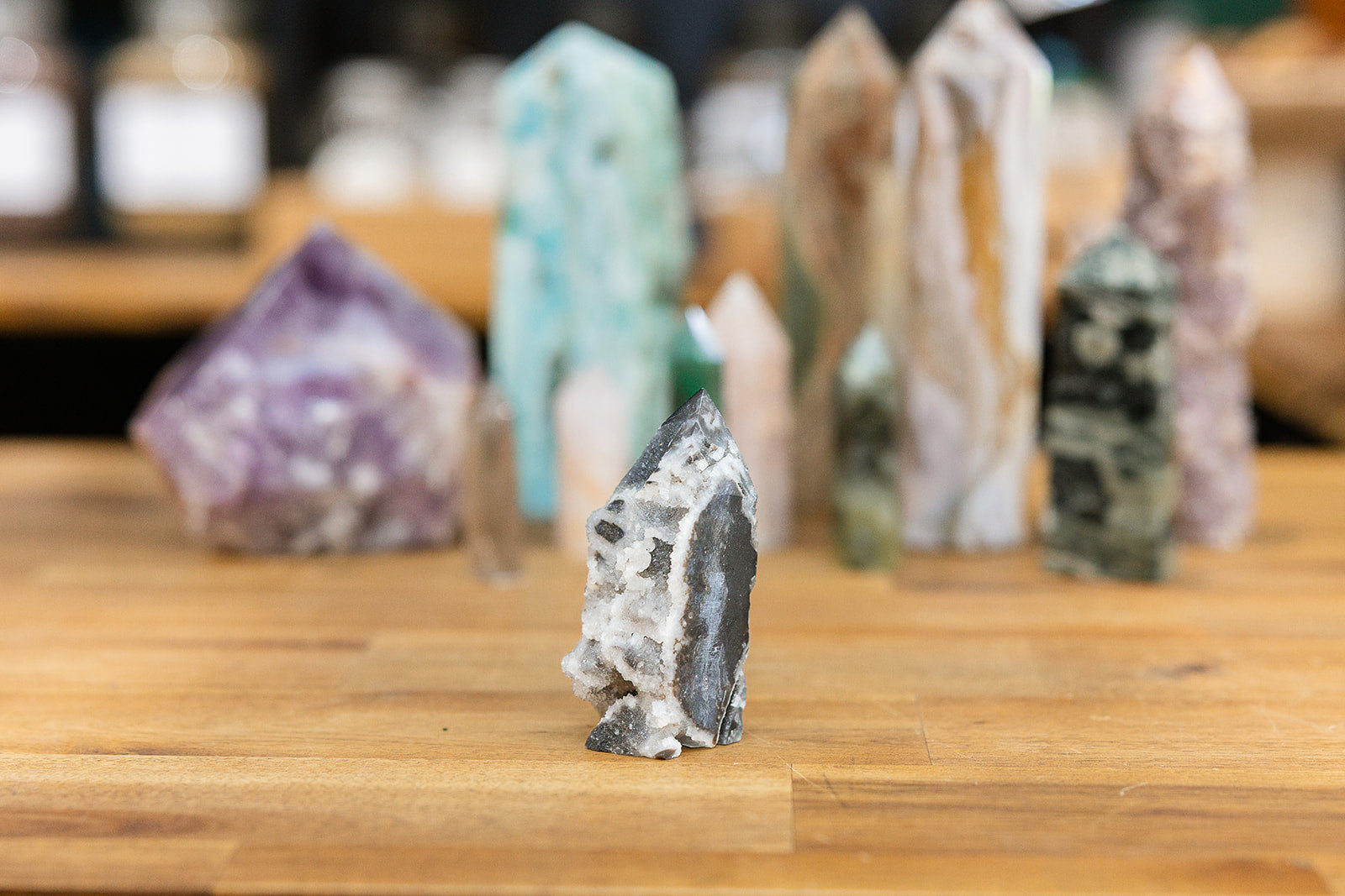 Natural crystal Sphalerite Tower with a collection of colourful crystal towers on a wooden background
