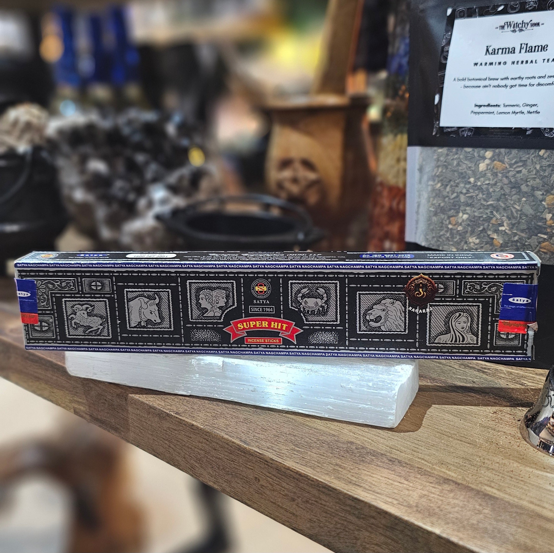 ‘Satya Super Hit Incense’ Displayed on a wooden table surrounded by crystals and herbs. 