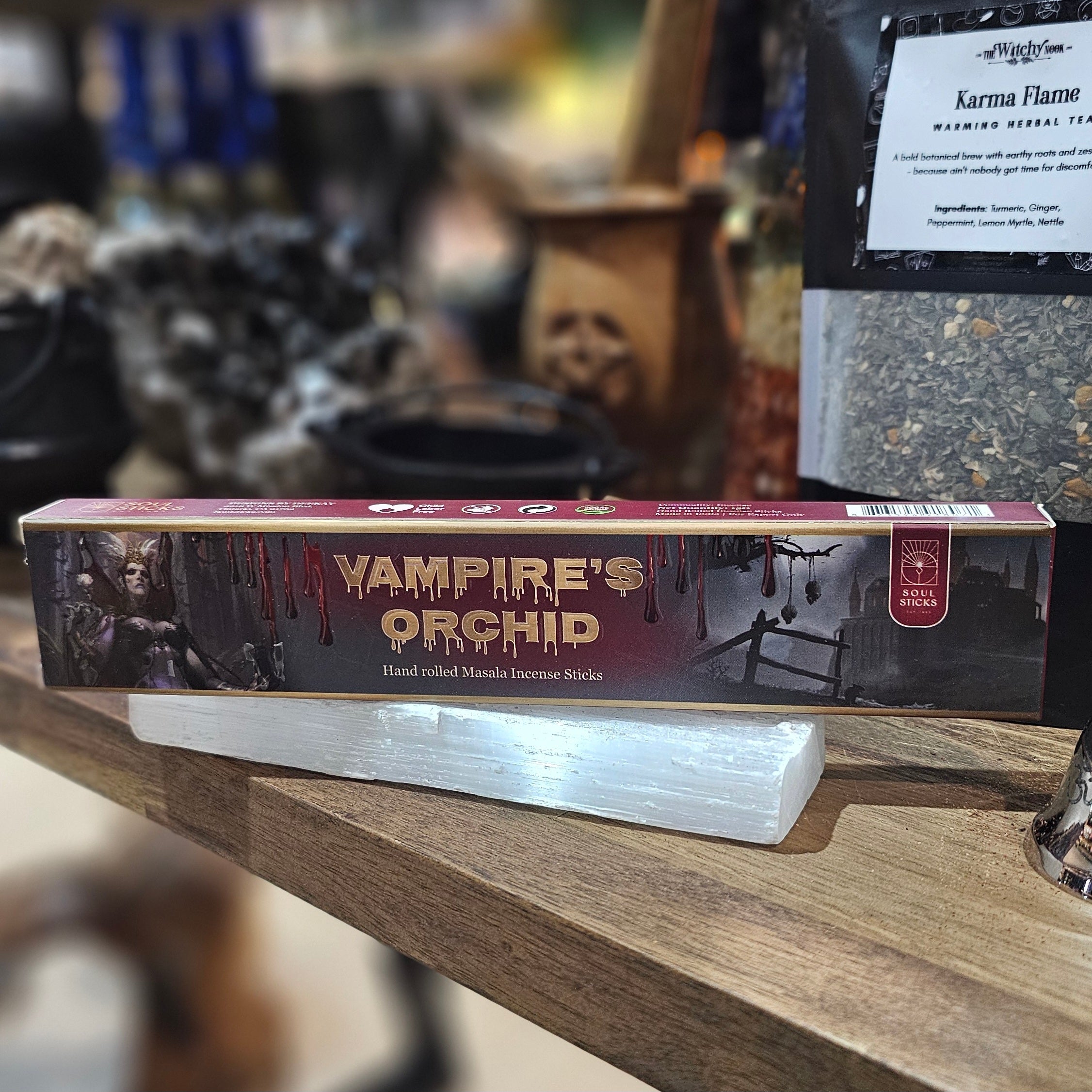 ‘Vampires Orchid Incense’ Displayed on a wooden table surrounded by crystals and herbs. 