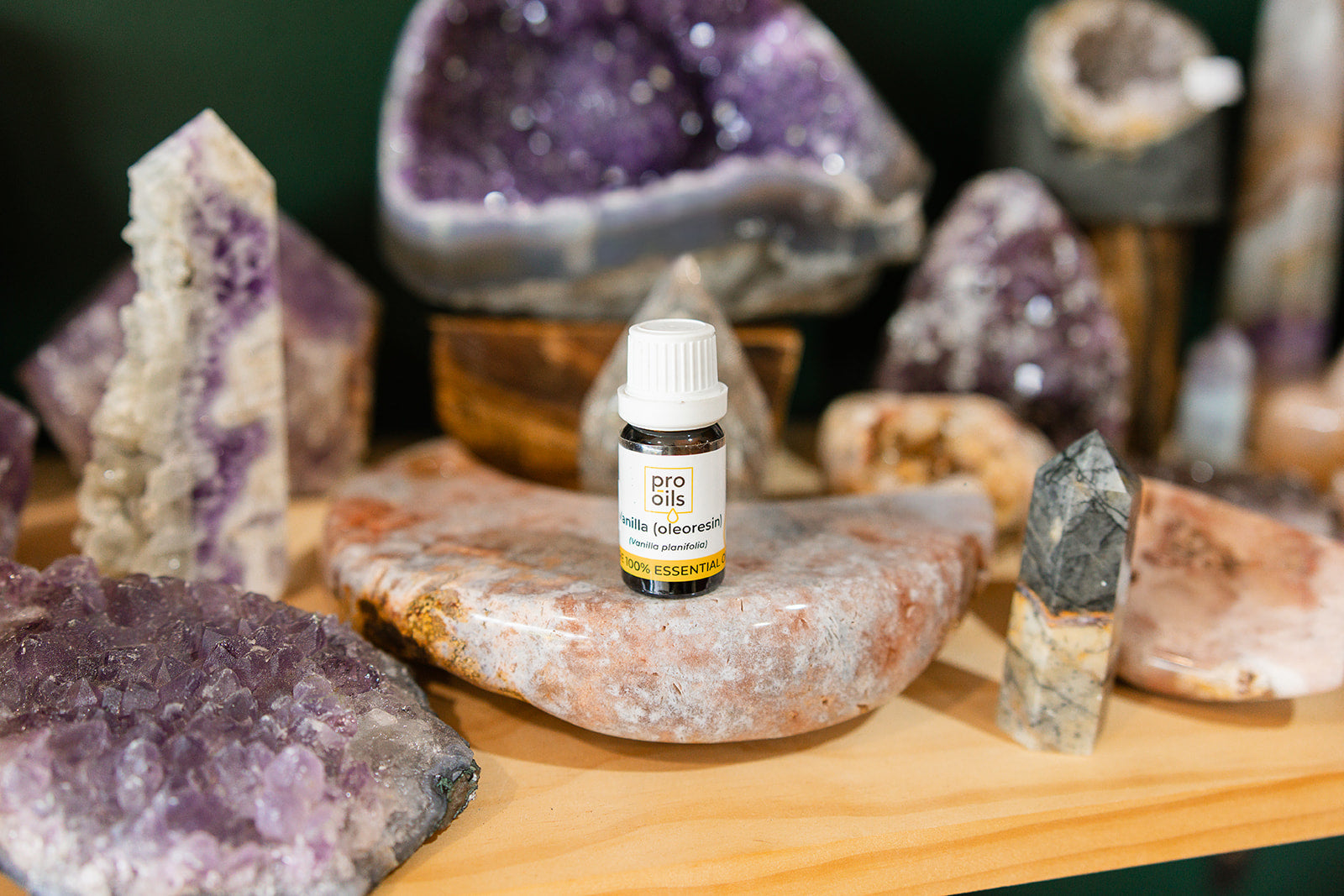 Bottle of Vanilla Oleoresin Essential Oil surrounded by a crystal display