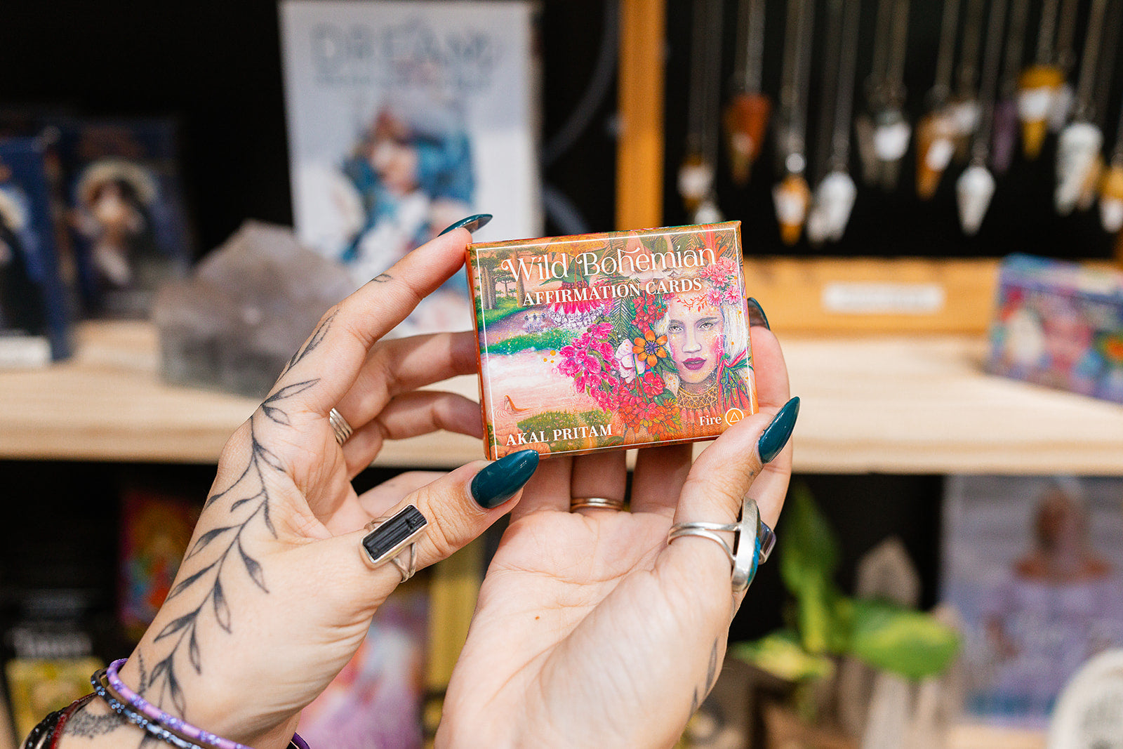 Hand holding a colorful card with text and graphics, with a blurred store background.