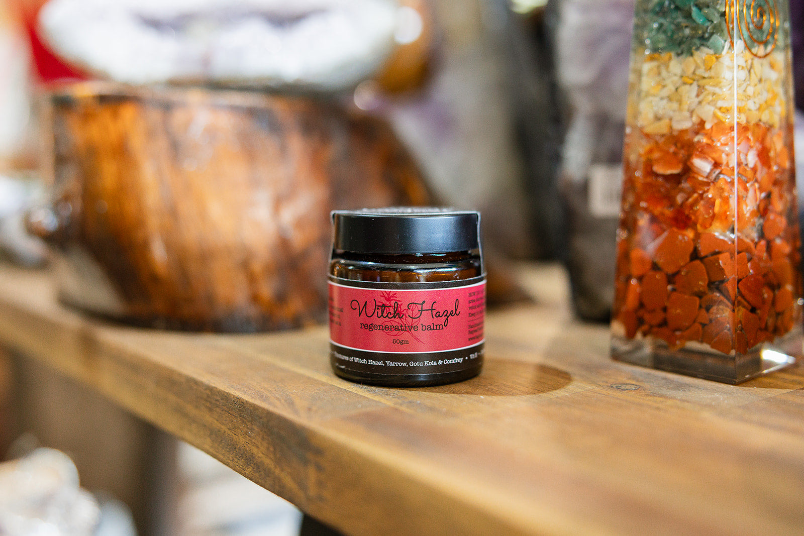 Balm and massage Witch Hazel Regenerative Blend displayed on wooden bench 