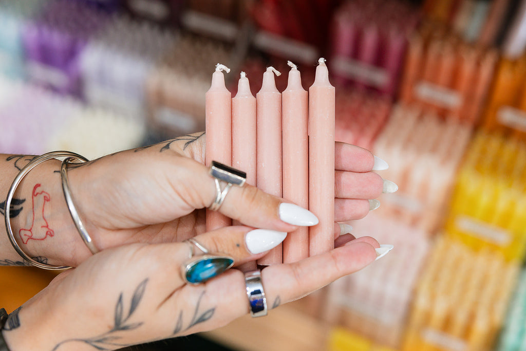 Person holding pink candles with a blurred store background