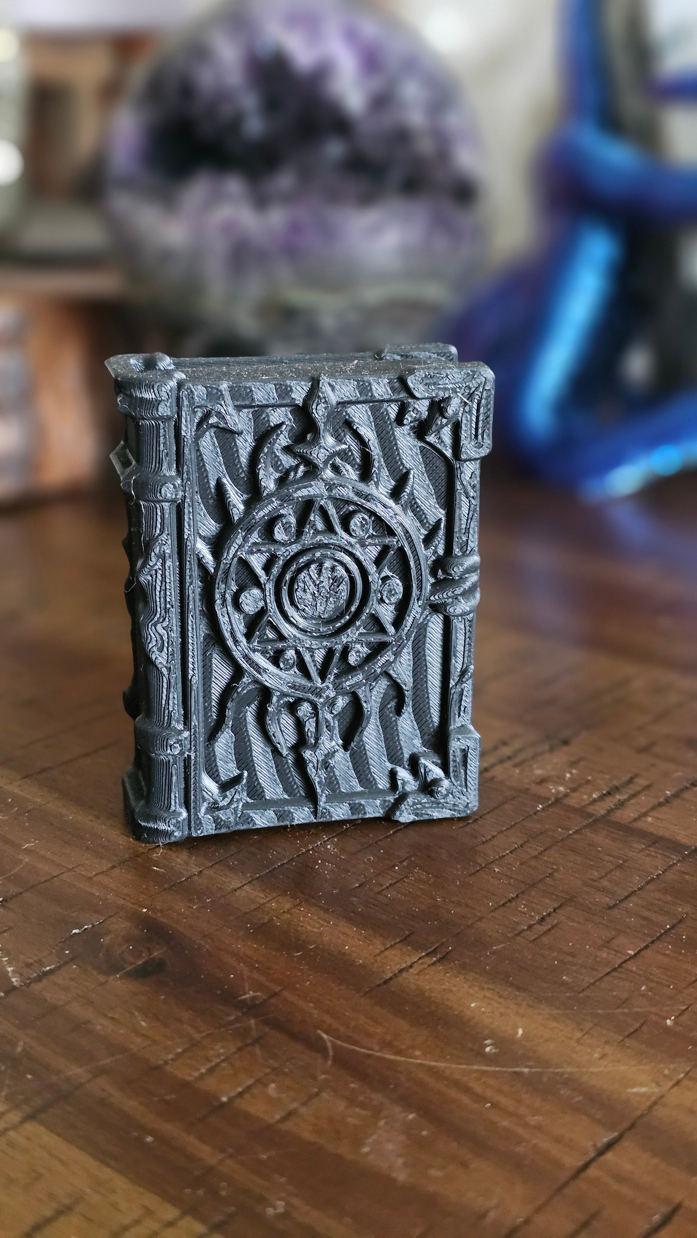 Forbidden spell book 3d PLA displayed on a wooden surface with crystals in the background. 