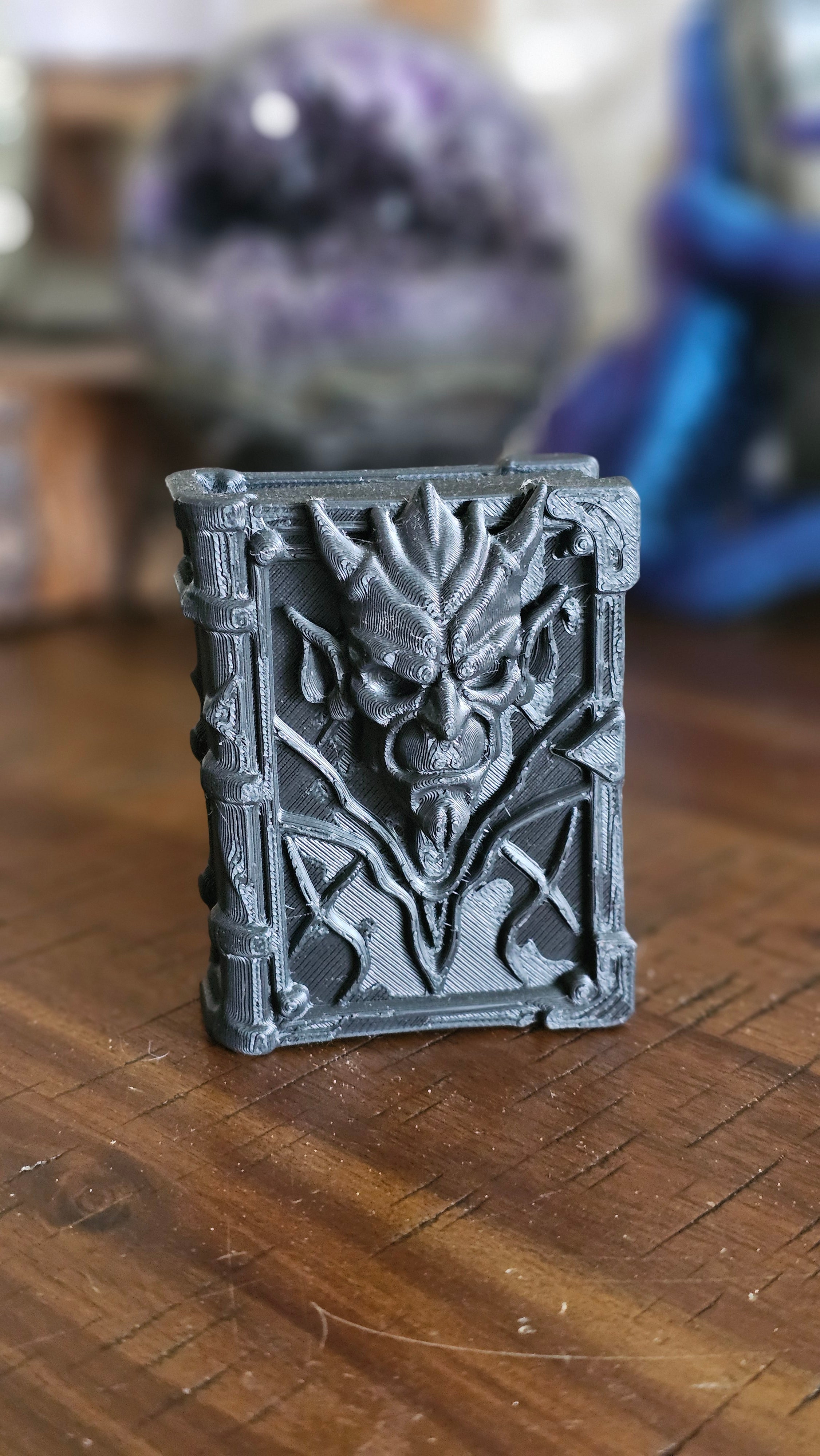 Forbidden spell book 3d PLA displayed on a wooden surface with crystals in the background. 