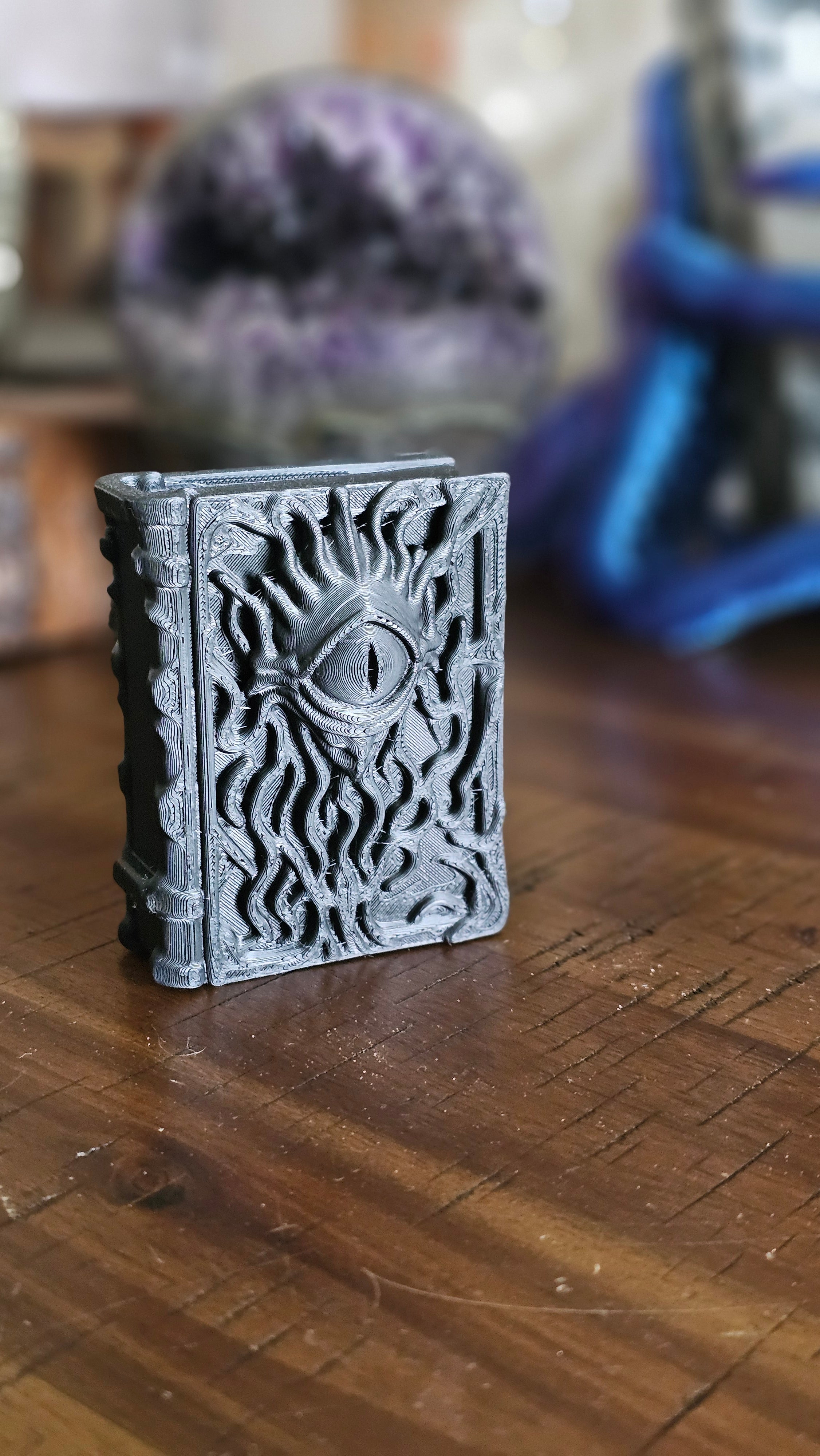 Forbidden spell book 3d PLA displayed on a wooden surface with crystals in the background. 