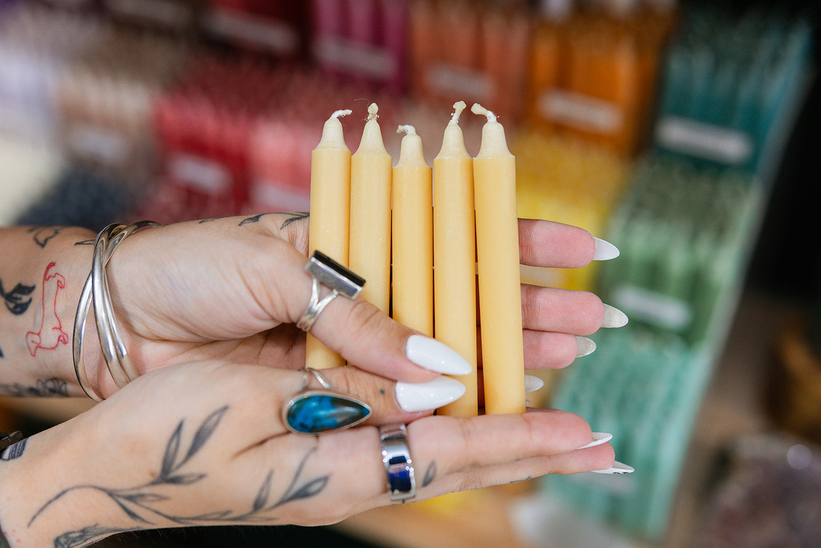 Hand holding five gold candles with a blurred store background
