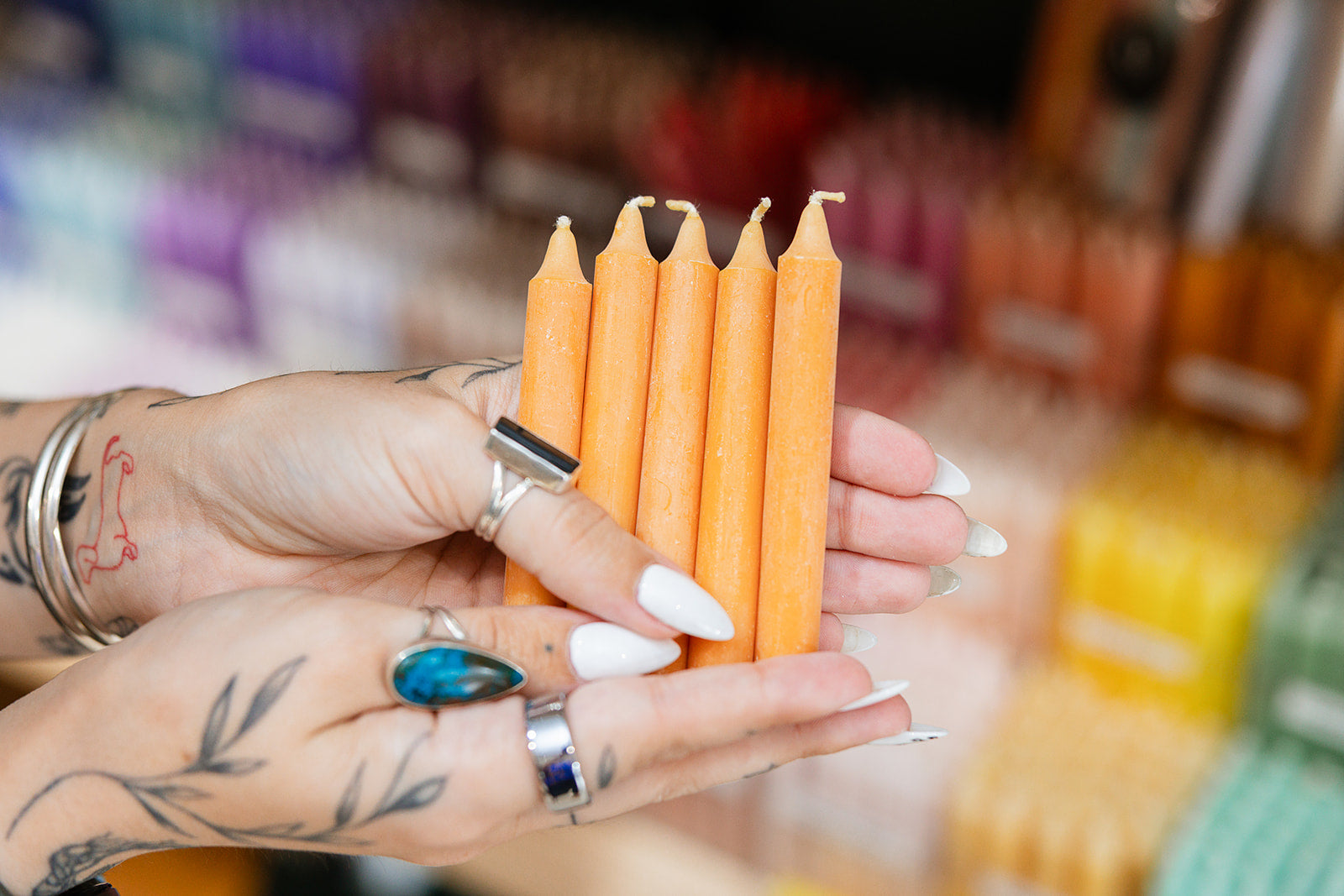 Person holding a set of orange candles with a blurred store background