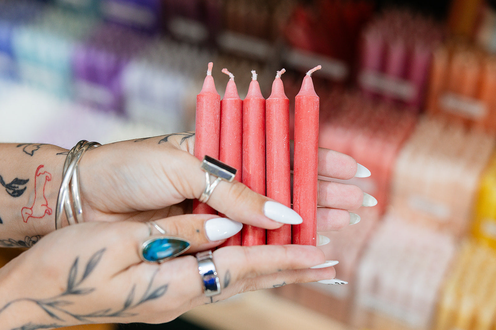 Person holding red candles with a blurred background