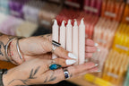 Person holding pink candles with a blurred background of more candles.