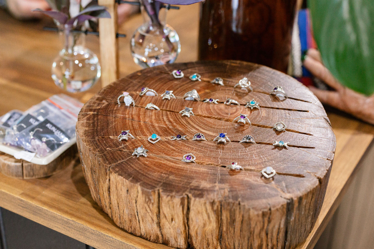 Wooden display of rings with coloured gems on a wooden surface