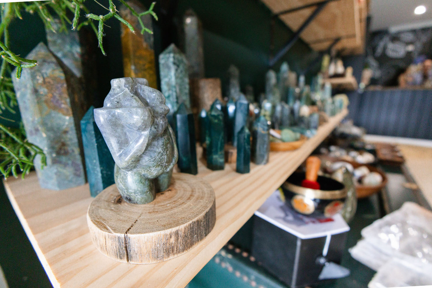 Decorative stone sculpture on a wooden stand with crystal towers in the background.