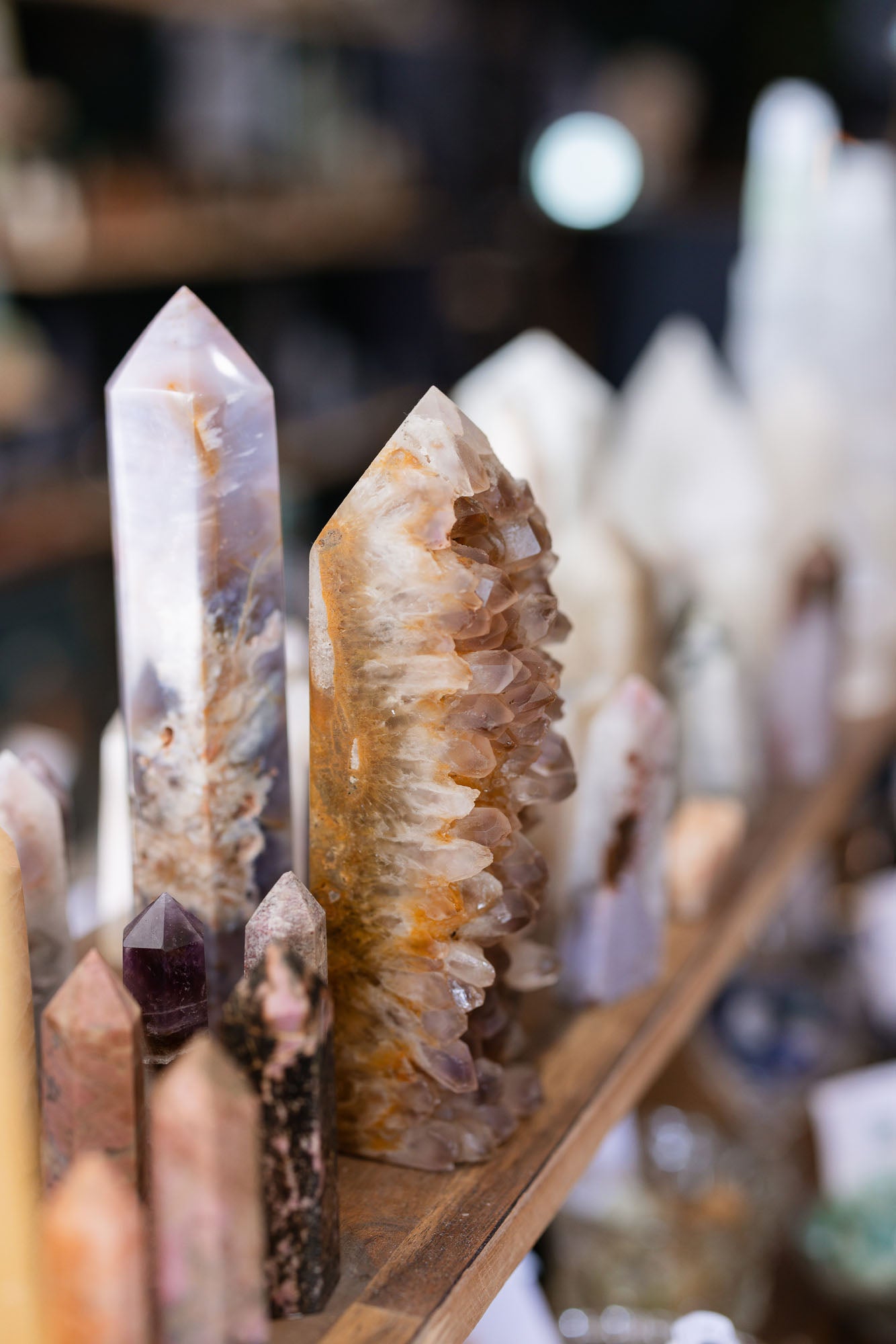 Close-up of crystal formations on a wooden shelf with a blurred background