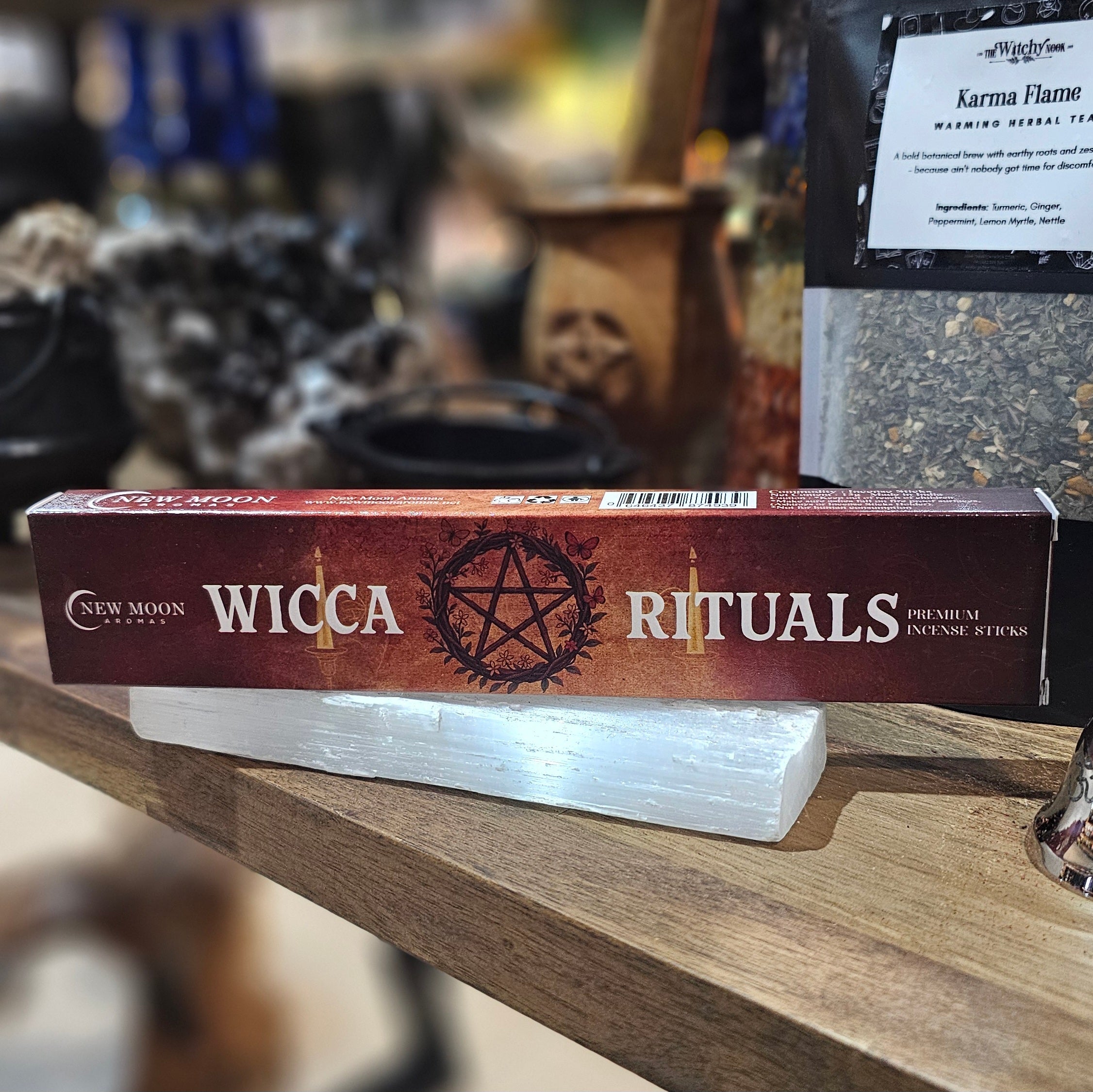‘Wicca Rituals Incense’ Displayed on a wooden table surrounded by crystals and herbs. 